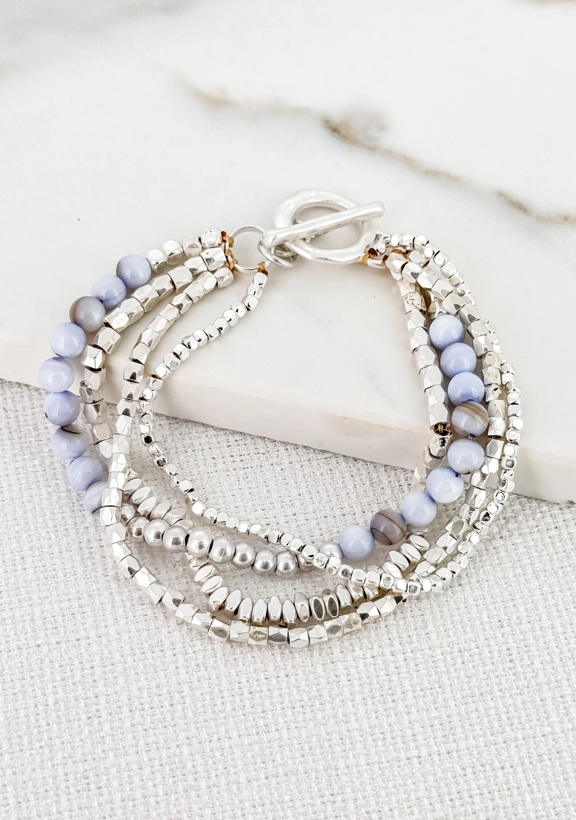 Envy Layered worn silver bracelet with blue semi precious beads and t-bar clasp