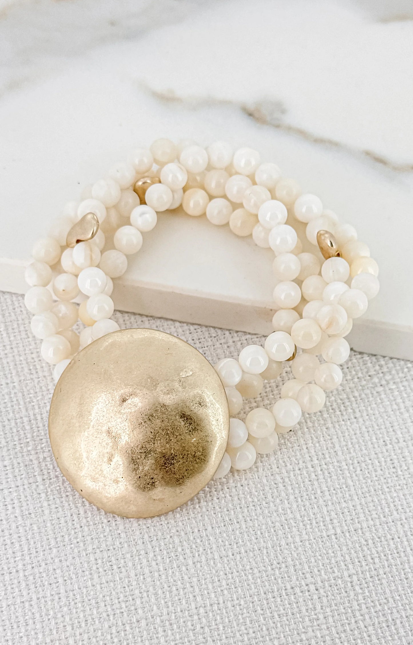 Envy Layered white shell bead bracelet with battered gold alloy circle